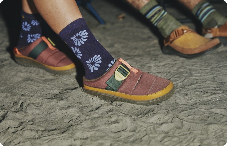 Chaco Ramble fleece-lined clogs worn with patterned socks on sand