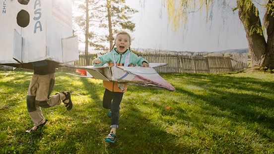 Two kids running in a park
