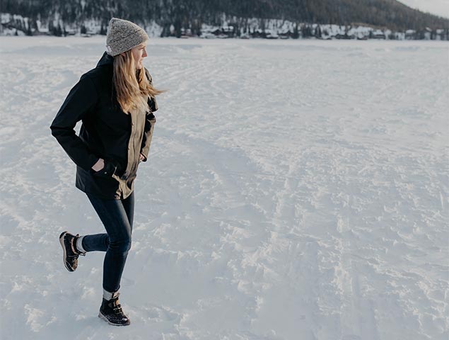Woman walking in the snow and ice staying warm in her Borealis Quilt boots.