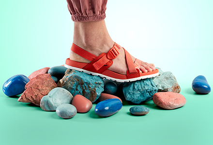 Close up of brown Chacos sandals standing on rocks.