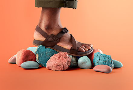 Close up of brown Chacos sandals standing on rocks.