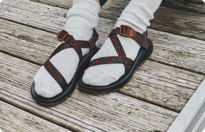 Chaco Z sandals worn with socks on a wooden dock
