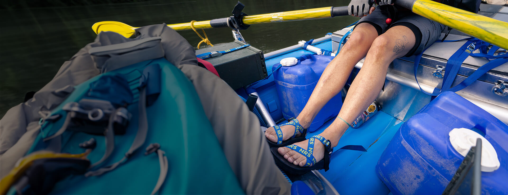 Person rowing a raft while wearing Chaco NRS Sandals.