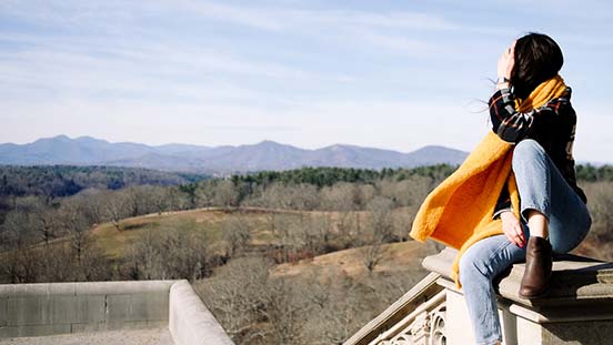 Woman looking out at the mountains with Chacos on.