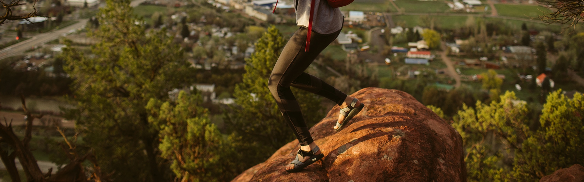 Woman standing on a rock wearing Chaco sandals.