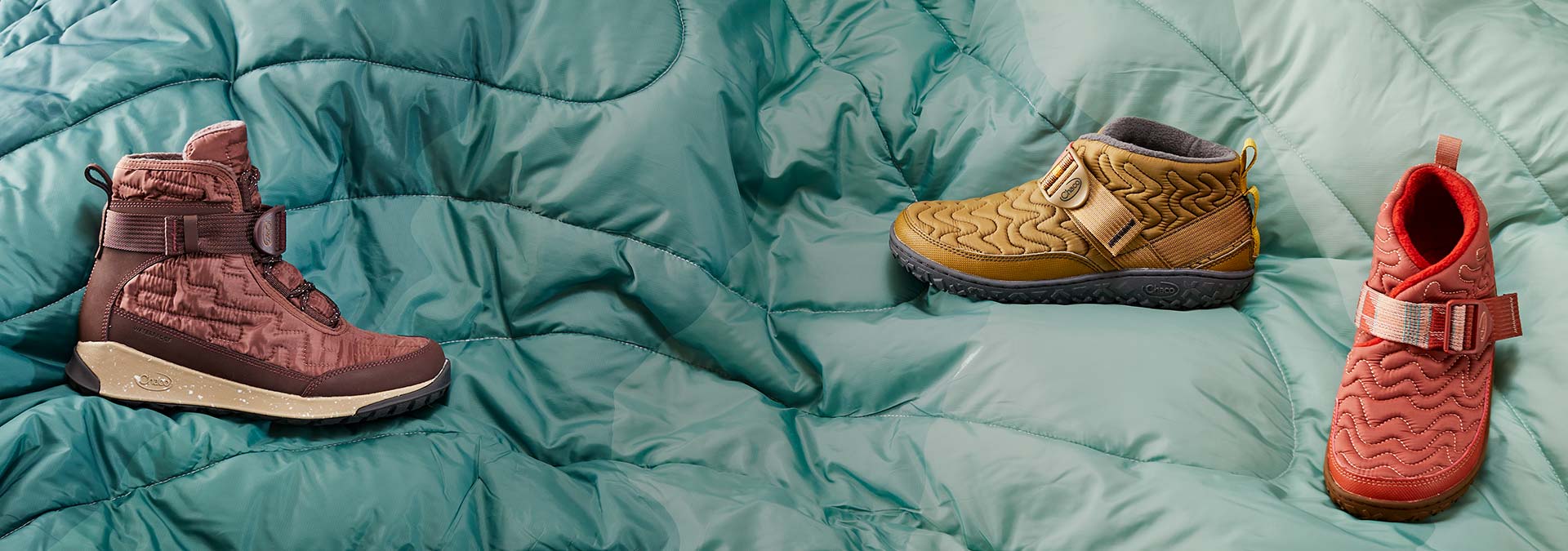 Ramble and Borealis Quilt boots in multiple colors laid out on a comforter.