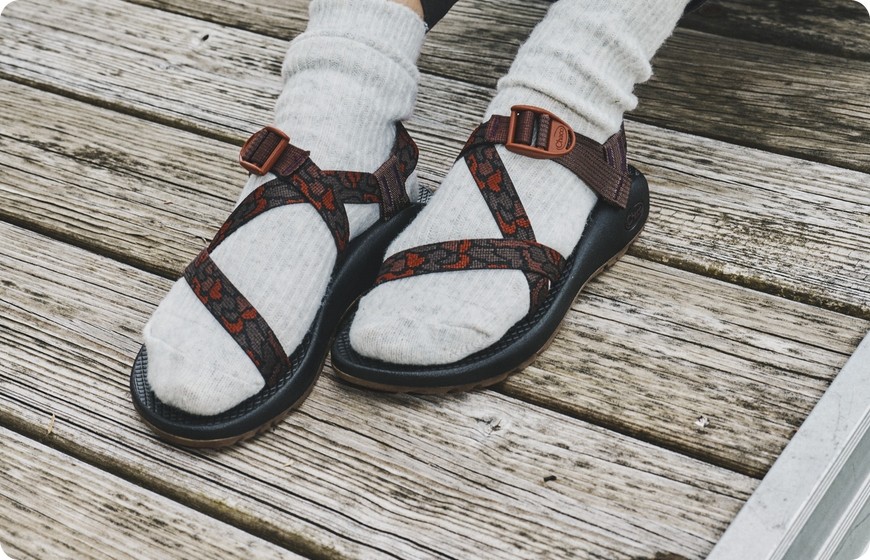 Chaco Z sandals worn with socks on a wooden dock