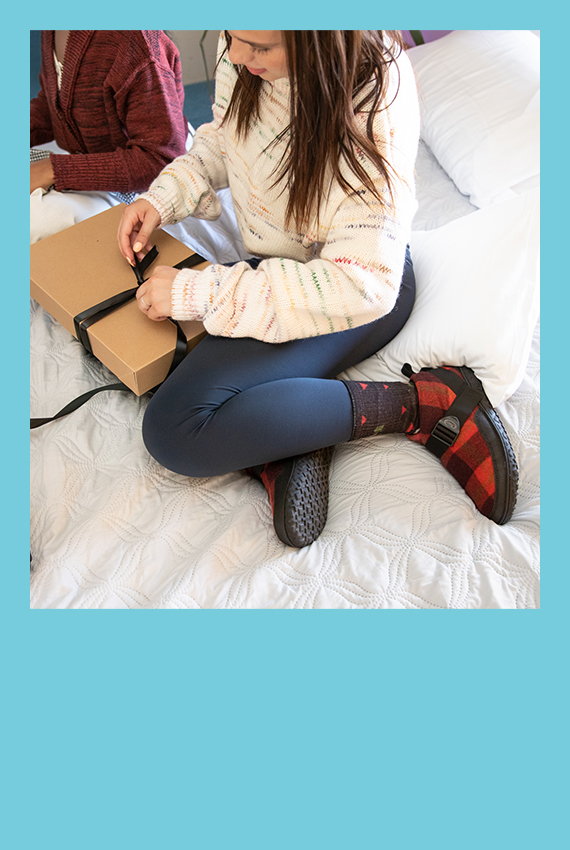 Two women wrapping gifts while rocking some comfy shoes.