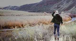Woman looking out at the mountains with Chacos on.
