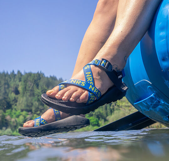 Man wearing Chaco NRS Sandals on raft.