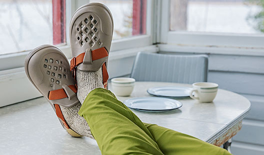 Person wearing Chillos Sneakers on picnic blanket.