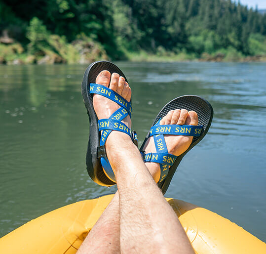 Man wearing Chaco NRS Sandals on raft.